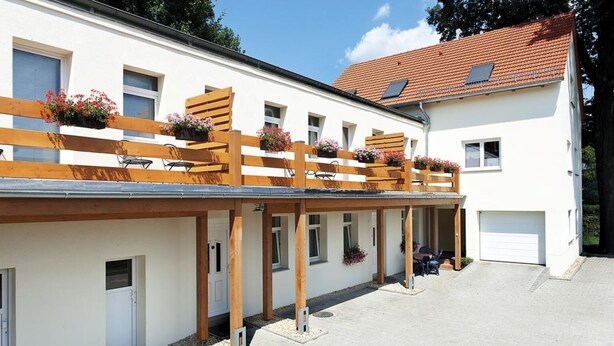 A two-story building with a covered patio area, wooden beams, and flower boxes. - apartment for 4 people with kitchen & balcony, view of the Elbe & free Wi-Fi (Dresden)