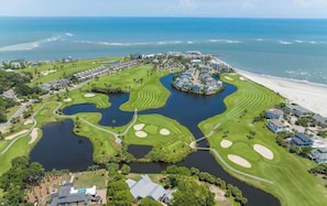 An aerial view of a golf course with water hazards, a beach, and a resort area. - 313 Ocean Point Drive (Fripp Island)