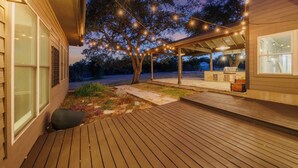 A wooden deck with string lights, a covered patio area, and a barbecue grill. - FREE LIMO, 2 ACRES Ranch 6 Rooms 3bath Sleeps 26 (Austin)
