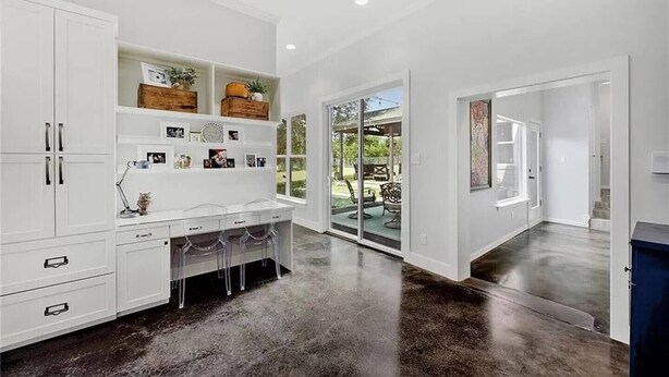 A spacious kitchen with white cabinetry, a dining area with bar stools, and a large sliding glass door leading to an outdoor patio. - FREE LIMO, 2 ACRES Ranch 6 Rooms 3bath Sleeps 26 (Austin)