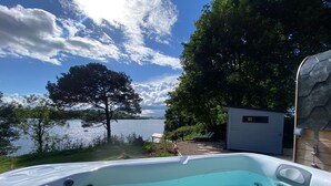 Un bain à remous avec vue sur un lac et des arbres.