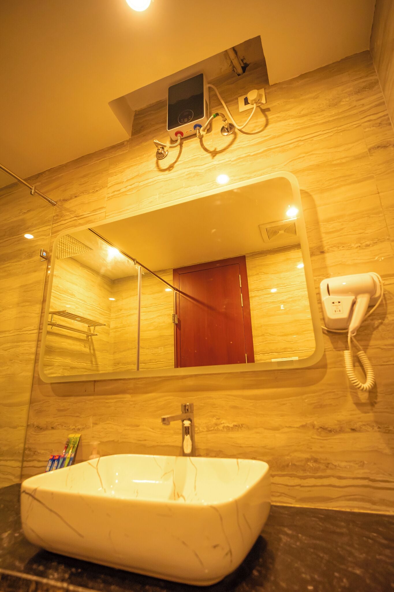 A bathroom with a marble sink, a mirror, a hairdryer, and a telephone.