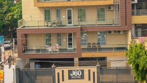 A multi-story hotel with a modern design, featuring balconies and a gated entrance. - J60 Suites (New Delhi)