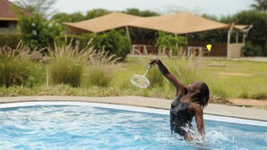 A swimming pool with a person playing with a water toy. - Olakira Mara Homes (Maasai Mara)