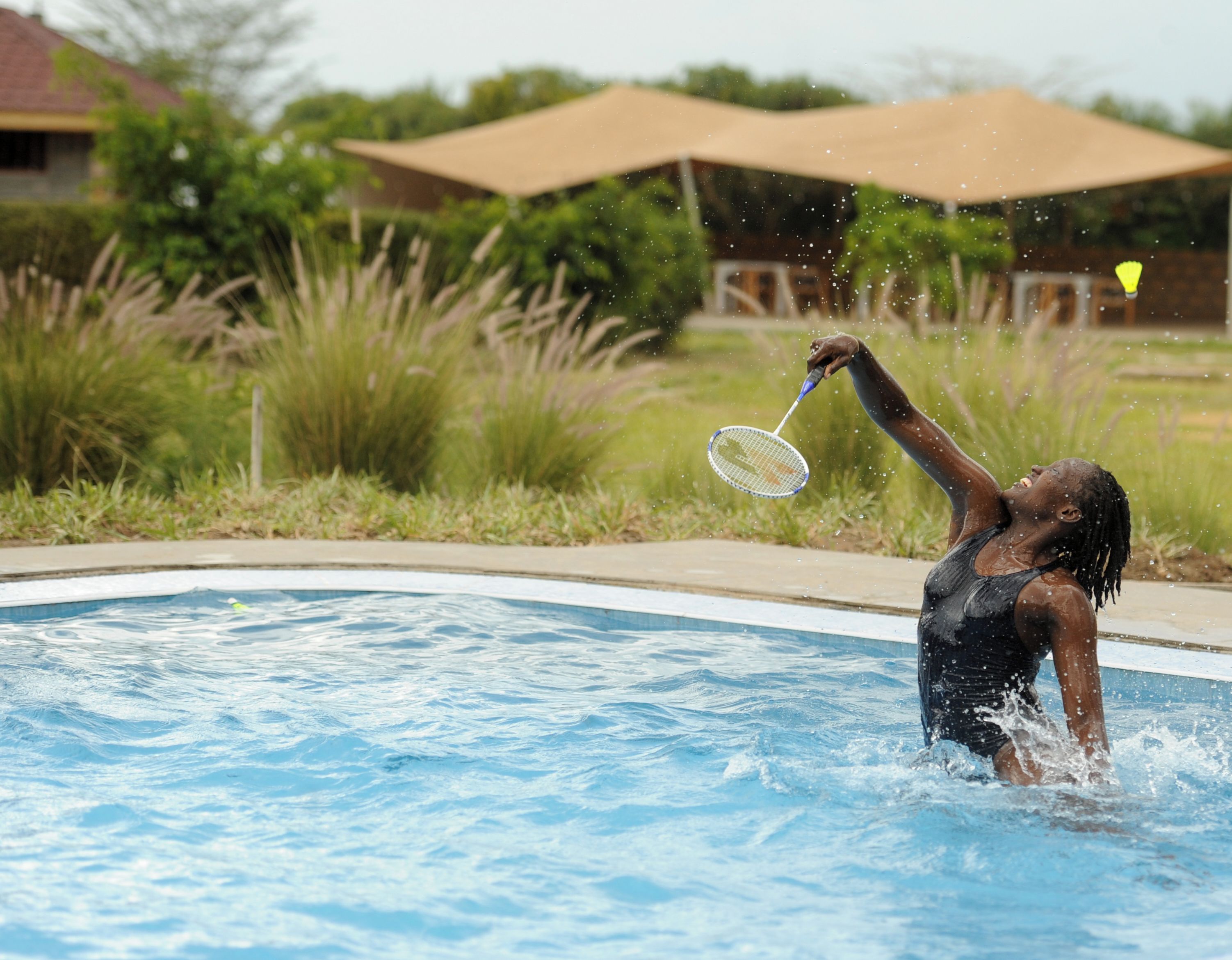 A swimming pool with a person playing with a water toy.