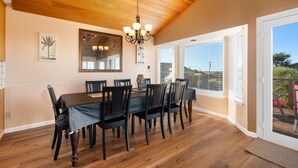 A dining area with a wooden ceiling, a chandelier, and a large window with blinds. - Welcome to 'Ocean Oasis' Located on Park Hill in Cambria! (Cambria)