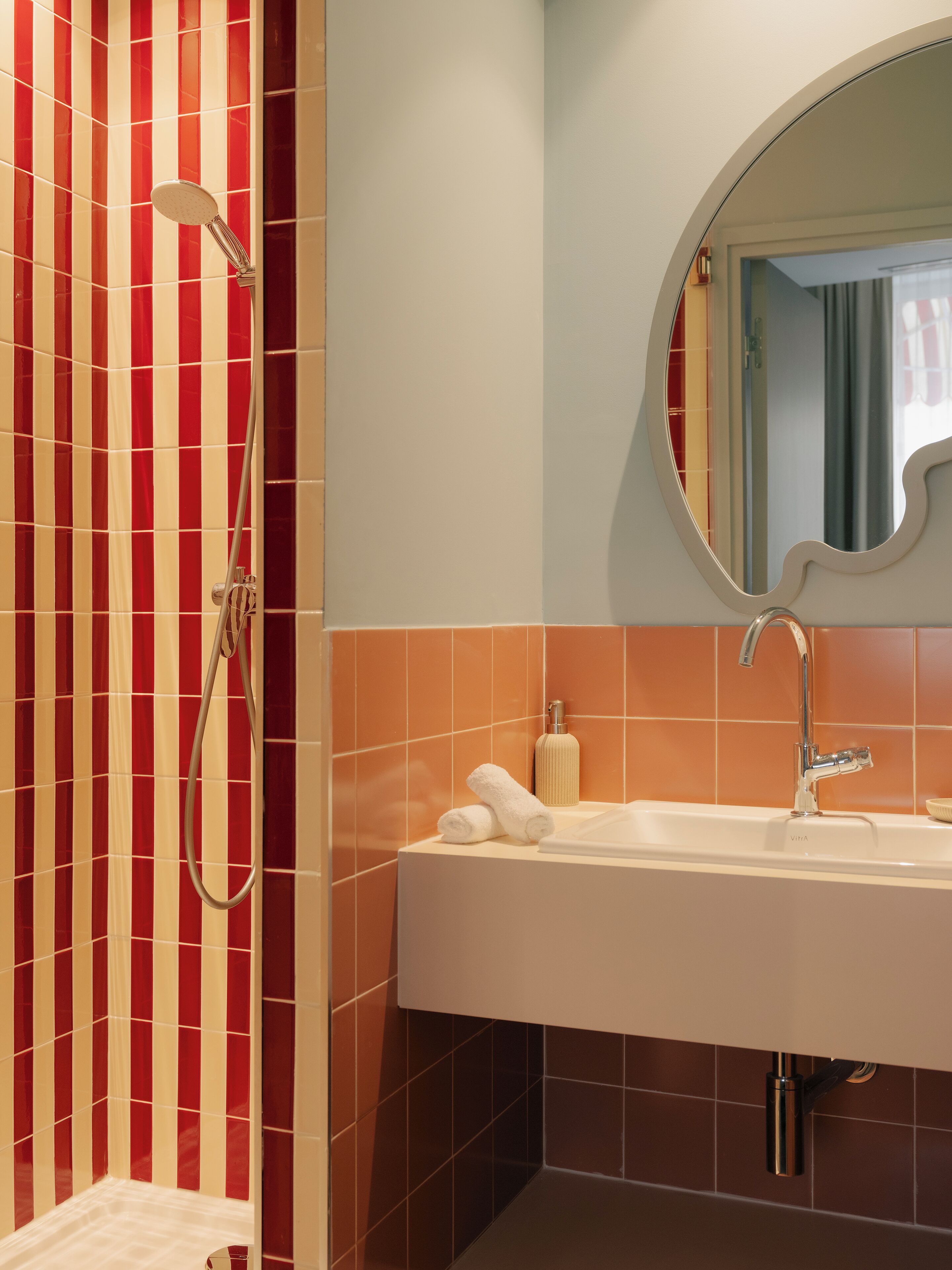 A bathroom with a shower, a sink, and a mirror.