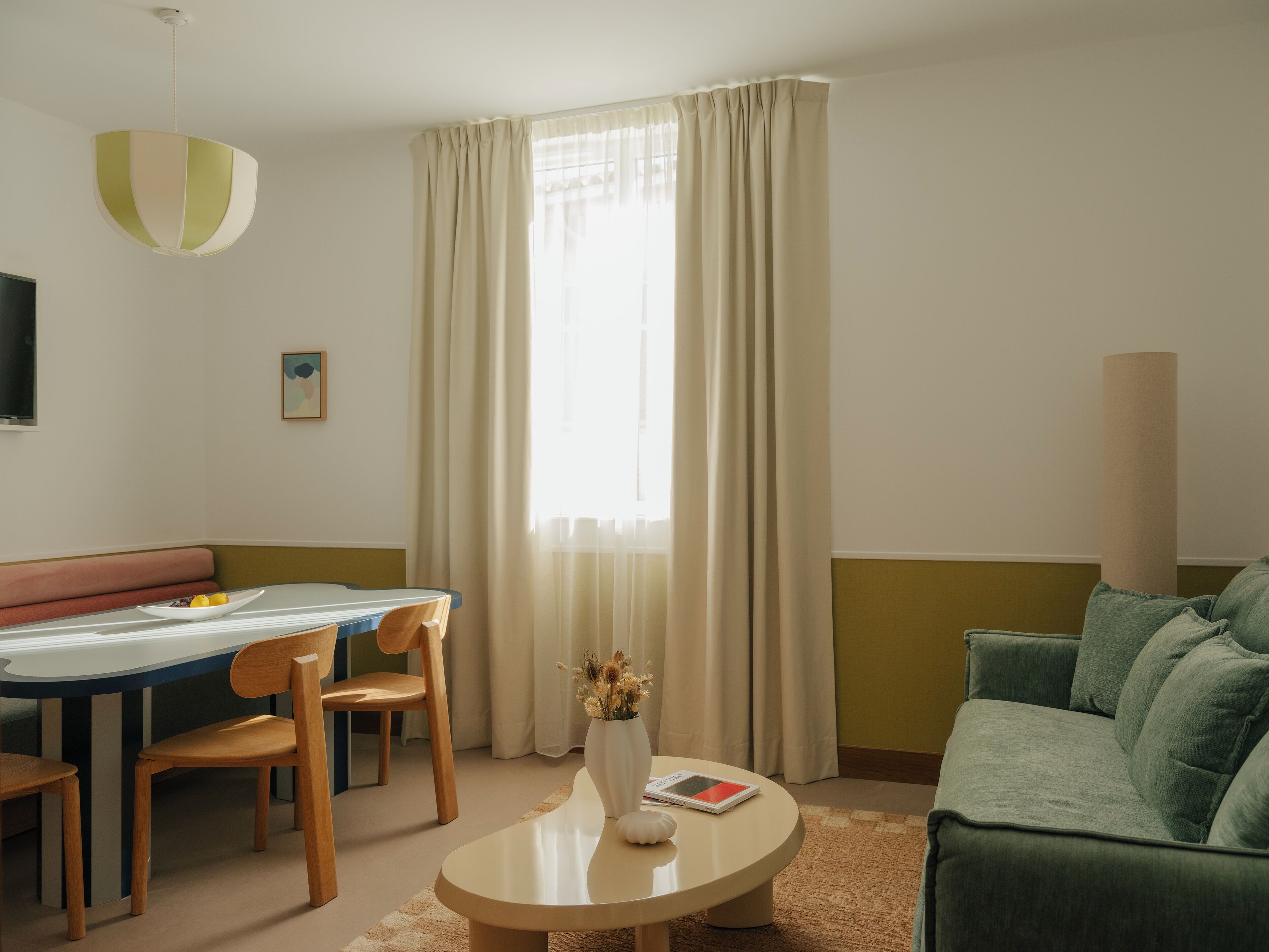 Una sala de estar moderna con comedor, un sofá, una mesa de centro y un televisor.