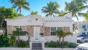 A small, single-story house with a tiled roof, a front door, and a small porch with steps leading up to it. - Southwinds Beach House • Jacuzzi • Sleeps 8 (Hollywood)