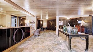 A lobby with a stone floor, wooden ceiling, a reception desk, and a table with decorative vases. - Bluesky 414: Ski-In/Out Peak 9, Private Hot Tub & Fireplace, Shuttle. (Breckenridge)