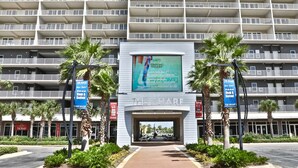 A hotel entrance with a sign for 'The Wharf' and a large digital billboard advertising. - Ocean View 1BR 2BA @ Fully Loaded Resort! (Panama City Beach)