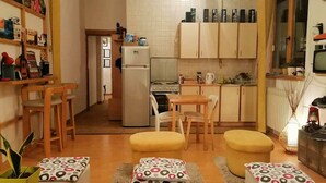 Cocina compacta con comedor, que incluye refrigerador, estufa y armarios.