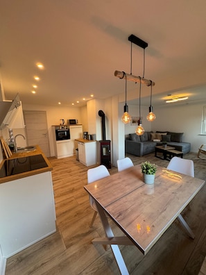 Eine moderne Küche mit Essbereich, Holzboden und einem eingebauten Backofen.