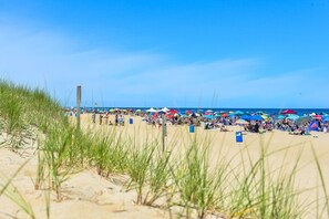A beach with people, umbrellas, and tents.