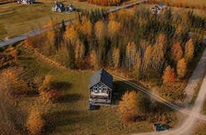A remote cabin surrounded by dense forest with a dirt road leading to it. - Spa & River View | Le Huppe (Petite-Rivière-Saint-François)