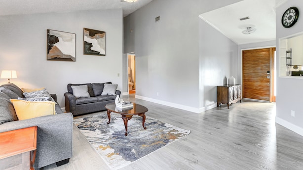 A modern living room with a grey sofa, a coffee table, and abstract wall art. - Port Charlotte Home Near Beaches & Dining (Port Charlotte)