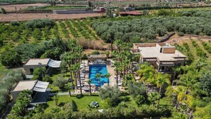 An aerial view of a resort with a swimming pool surrounded by palm trees and a variety of buildings. - 
luxury Villa Marrakech  (Marrakech)