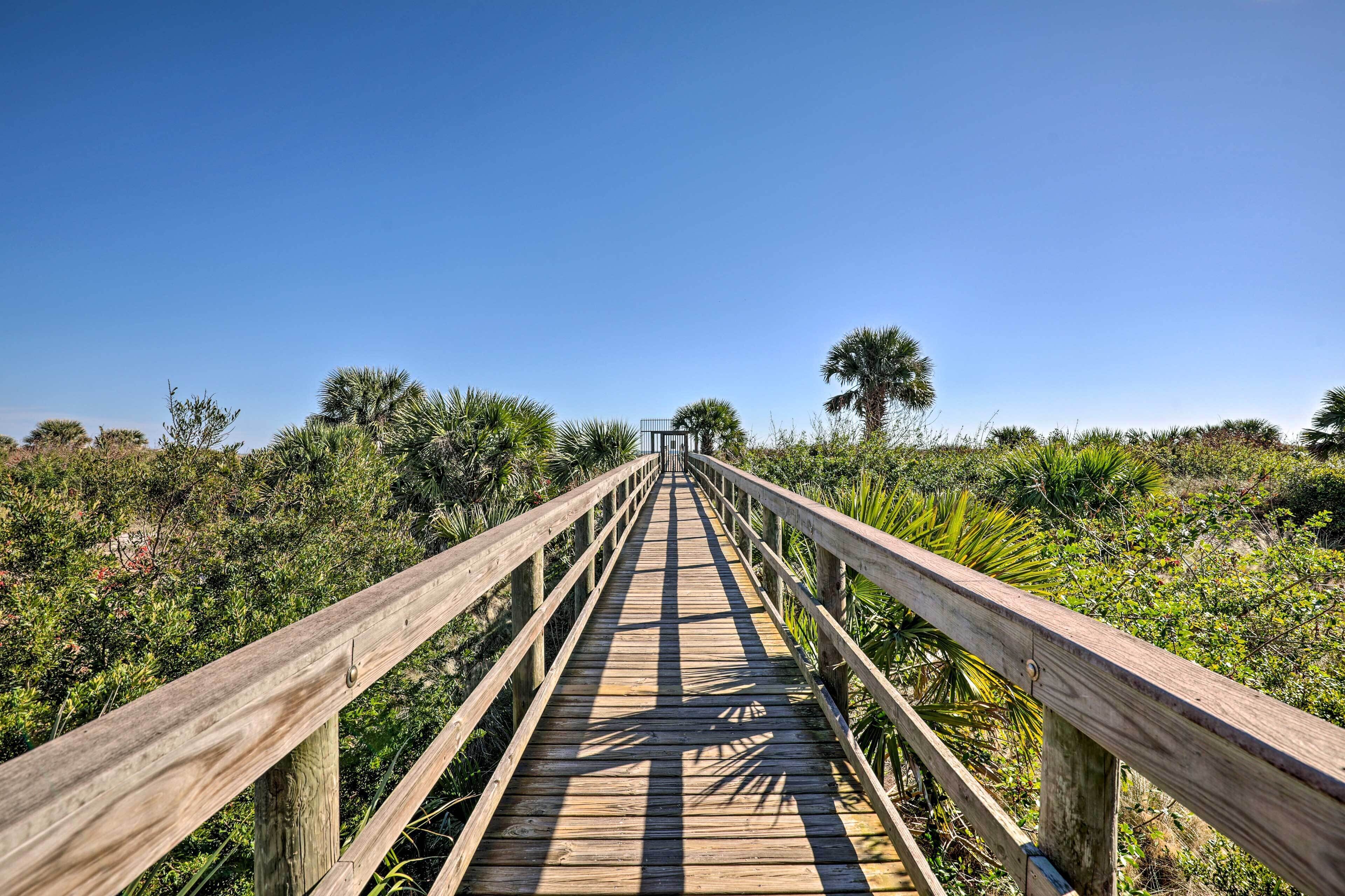 A wooden boardwalk leading through a natural area with dense vegetation.