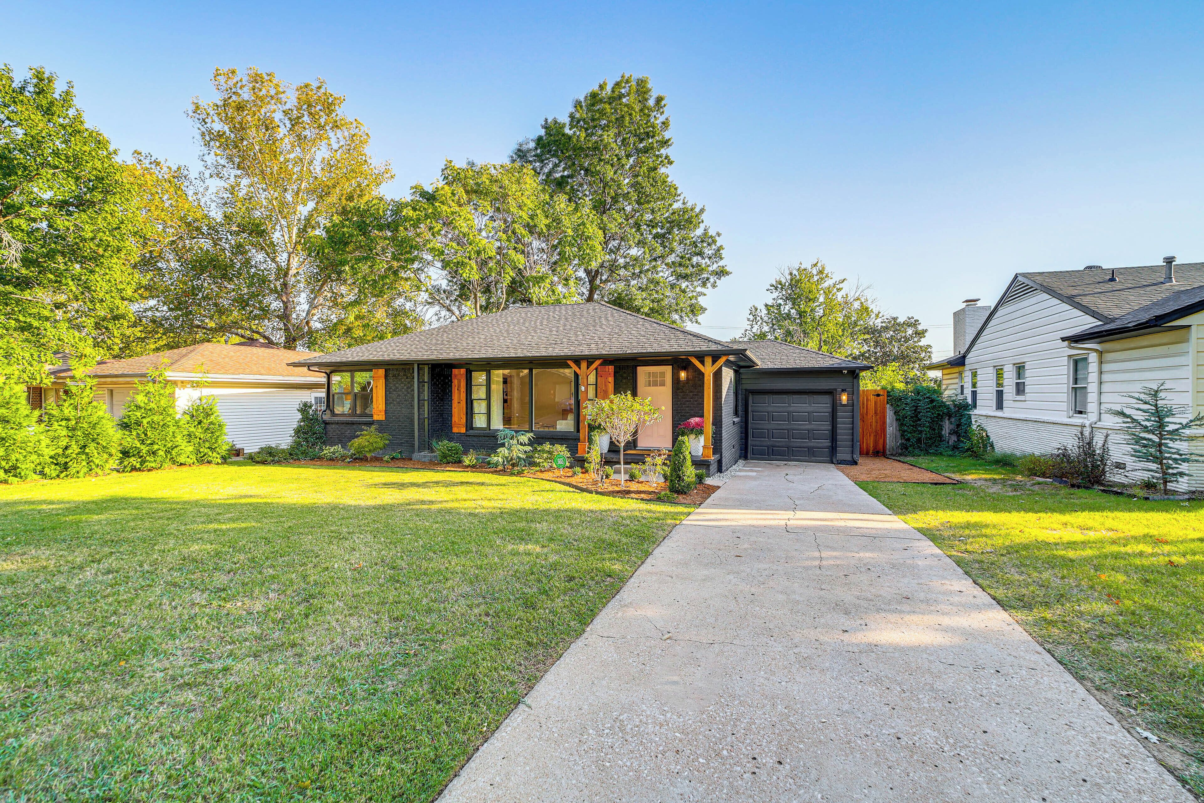 A single-story house with a front porch, a garage, and a well-maintained lawn.