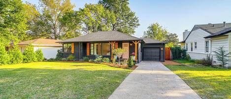 A single-story house with a front porch, a garage, and a well-maintained lawn.