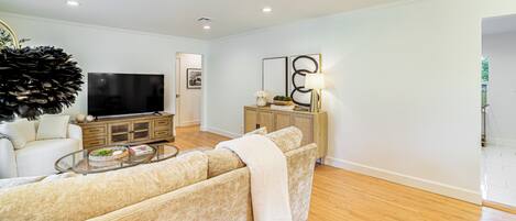 A living room with a sofa, a coffee table, a TV, and a cabinet.