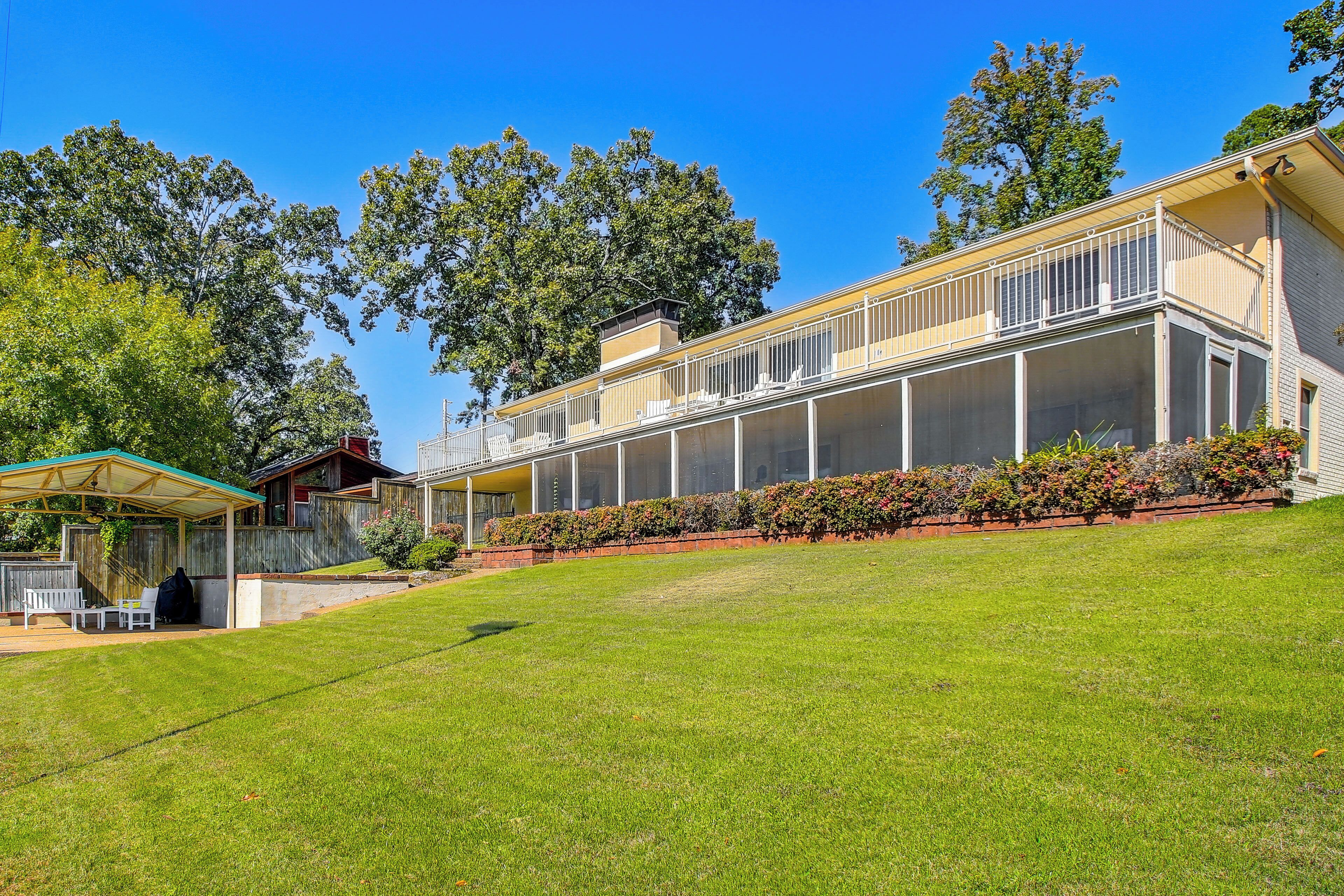 A two-story house with a covered patio and a large lawn.
