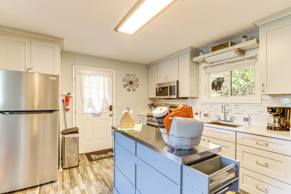 A modern kitchen with white cabinets, stainless steel appliances, and a blue island. - < 1 Mi to Dtwn: Pet-friendly Cabin in Murphy! (Murphy)