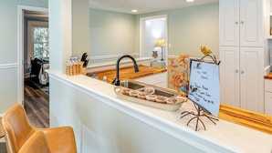 A kitchen with a white countertop, a sink, and a sign indicating fresh baked pumpkin spice muffins. - Small-town Charm & Local Dining: Home in Burgaw! (Burgaw)