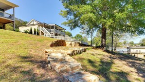 A house with a porch, steps leading up to it, and a large tree in the foreground. - Waterfront Lake Hickory Retreat w/ Private Dock! (Hickory)