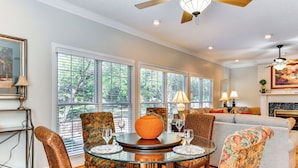 A spacious living room with a round glass table, floral upholstered chairs, and a grey sofa. - 1 Mi to Dtwn: Home w/ Fire Pit & Deck in Hudson! (Hudson)