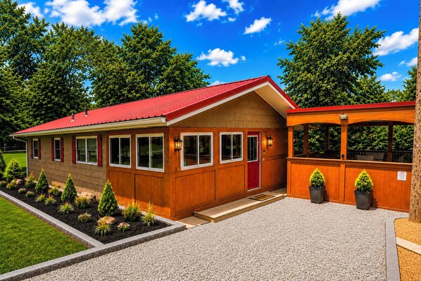 A wooden building with a red roof, a red door, and a covered porch area. - Unwind Near the Lake Fire Pit Marina Nearby (Bronston)