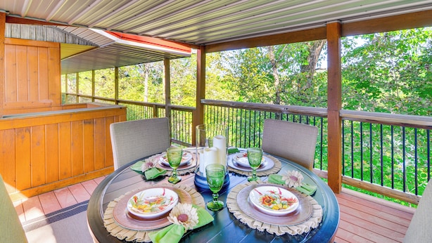 A covered outdoor dining area with a table set for four, surrounded by chairs, and a wooden deck with a railing. - Unwind Near the Lake Fire Pit Marina Nearby (Bronston)