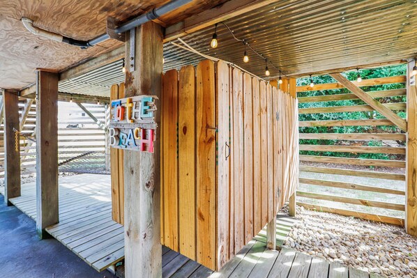 Una estructura de madera con un cartel que dice 'To the Beach' y una valla de madera al fondo.
