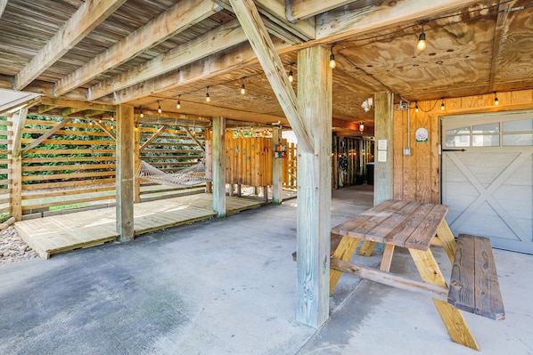 A wooden structure with a bench and a table, a wooden fence, and a door.