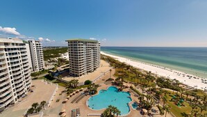 A resort with a large pool, beachfront, and high-rise buildings.