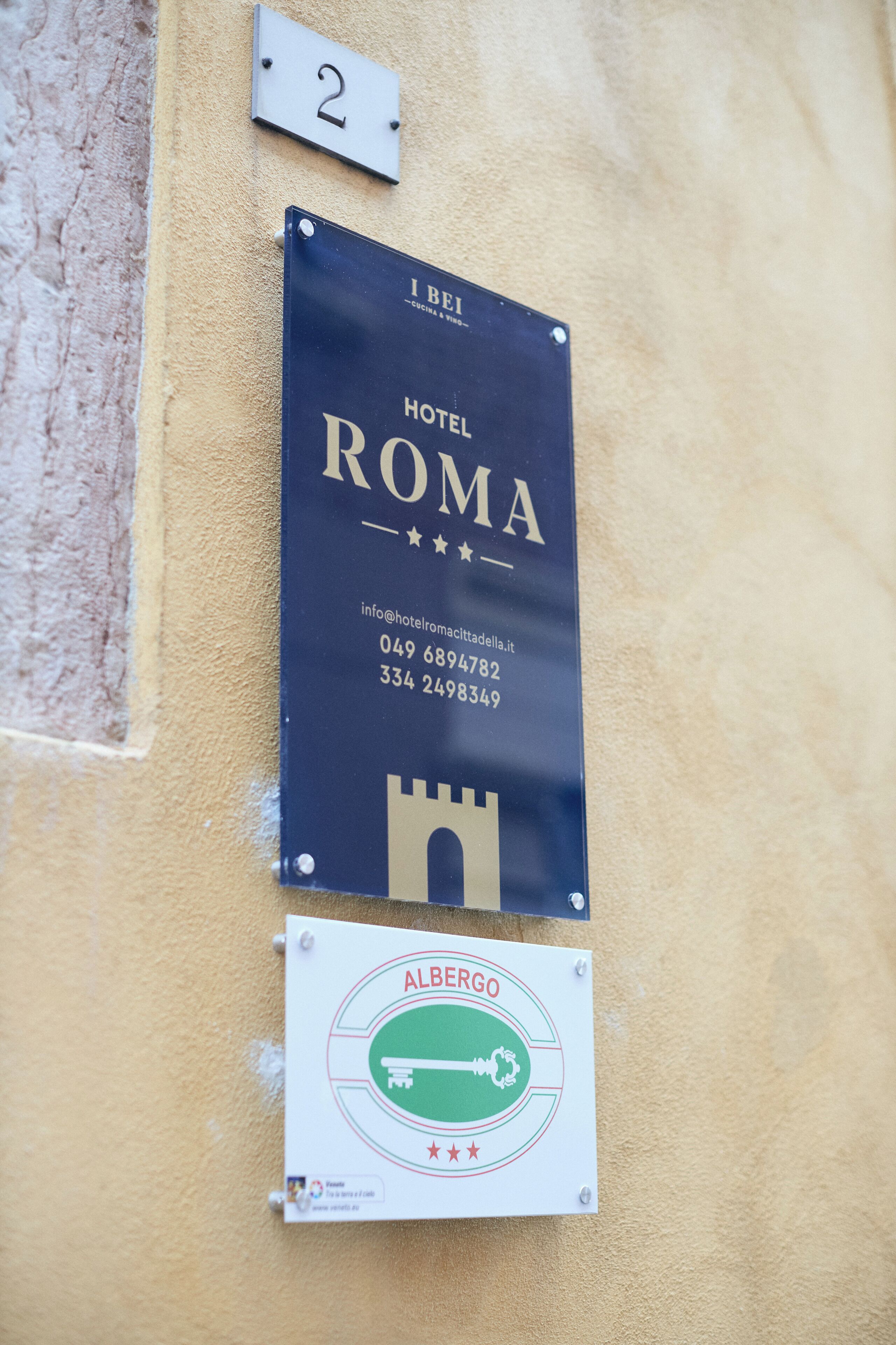 A hotel sign with the name "HOTEL ROMA" and contact information.