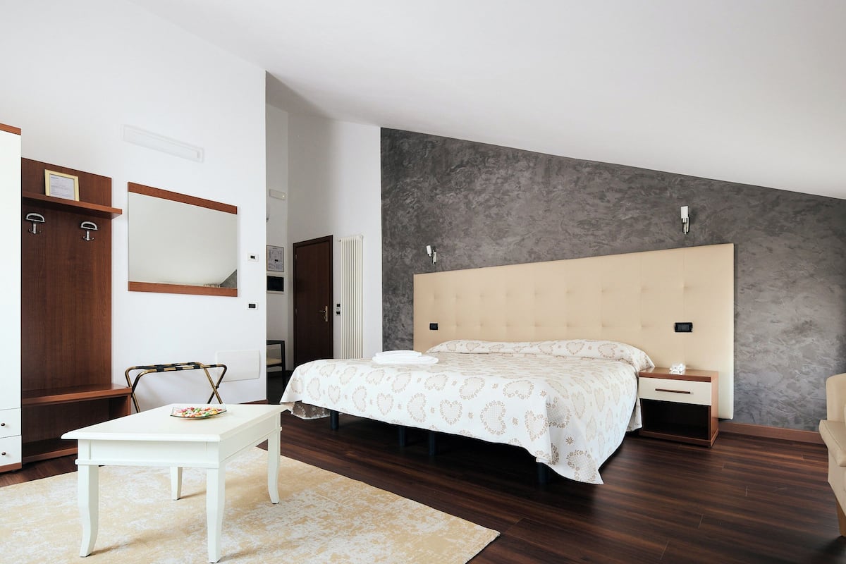 Ein Schlafzimmer mit Bett, Nachttisch, Schrank und einem Kleiderschrank.