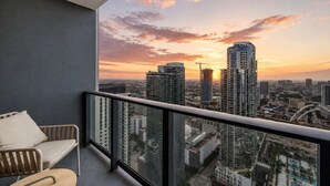A balcony with a city view at sunset, a chair, and a table. - Stylish 1BR | Free Parking | Pool | Downtown Miami (Miami)