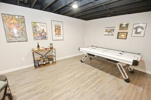 Ein Zimmer mit Billardtisch, gerahmten Sportmemorabilien an den Wänden und einer kleinen Ablagefläche mit Gegenständen.