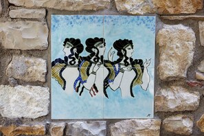 Ein Mosaik von drei Figuren an einer Wand mit steinerner Hintergrund.