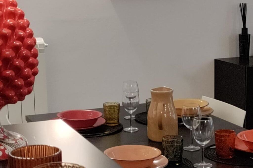 A dining table set with plates, glasses, and a pitcher.