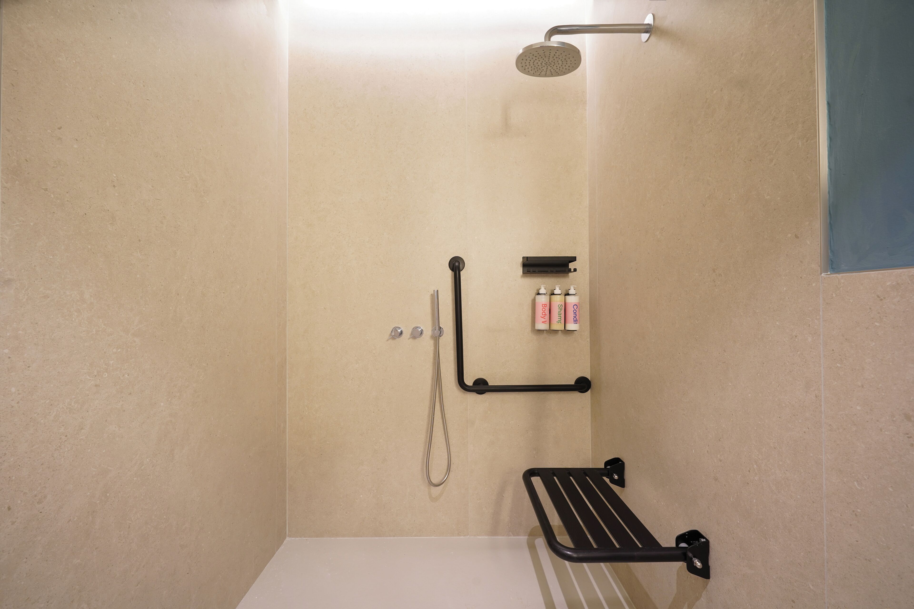 A bathroom with a shower, a towel rack, and toiletries.