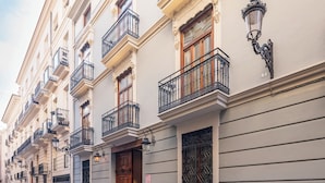 Una hilera de edificios de estilo europeo tradicional con balcones ornamentados y trabajos de hierro decorativos.