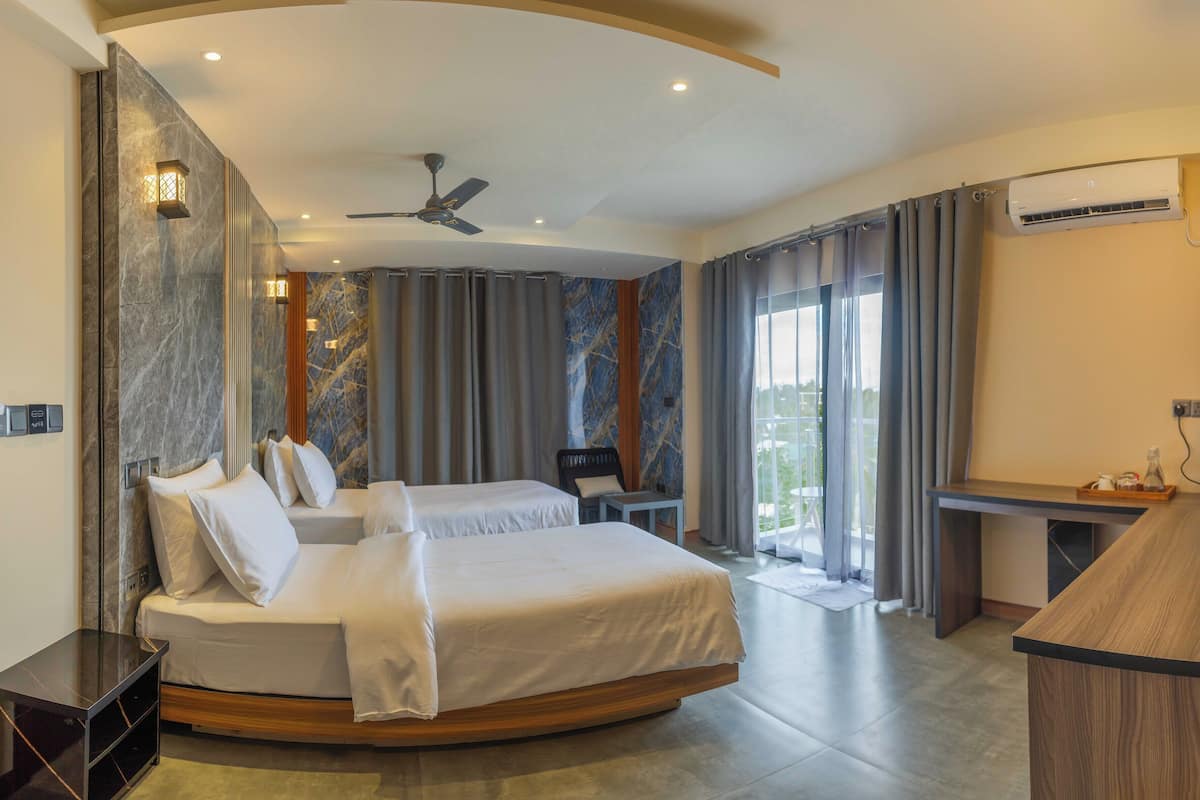 A hotel room with a bed, a desk, a chair, a ceiling fan, and an air conditioning unit.