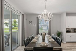 Spacious Dining for Gatherings: 
Gather around the 8-seater dining table, perfect for family meals, celebrations, and group get-togethers in a spacious, well-lit area. - Resort Access: 6BR Home w Pool near Disney (Kissimmee)
