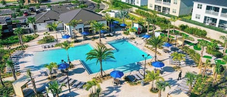 A resort with a central swimming pool, lounge areas, and a landscaped garden.