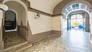 A hallway with a tiled floor, a staircase, and an arched doorway leading outside. - Eclectic Apartment 1 in Vasto by Wonderful Italy (Napoli)