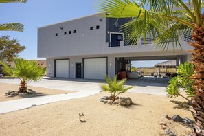 A modern two-story house with a garage, a patio area, and a pool.