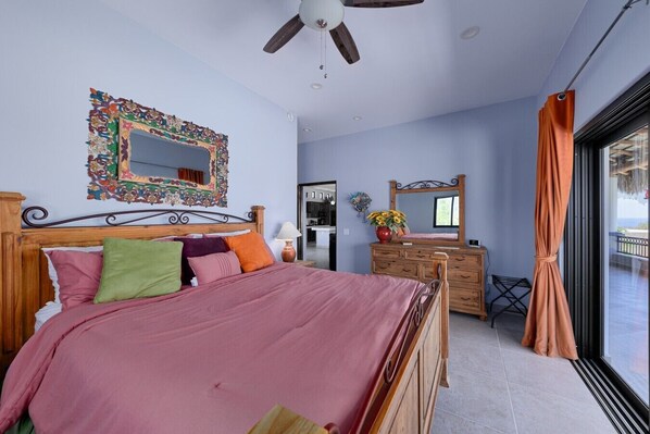 Une chambre à coucher avec un lit, une commode, un miroir et une vue sur l’extérieur.