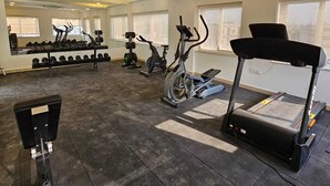 A gym with treadmills, stationary bikes, and dumbbells. - Western Suites (Hyderabad)
